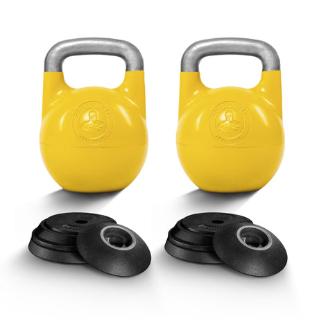 Two yellow Bells of Steel Adjustable Competition Kettlebells with gray handles stand upright, each displaying the brand logo. Several black weight plates are stacked in front of each kettlebell, all set against a white background.