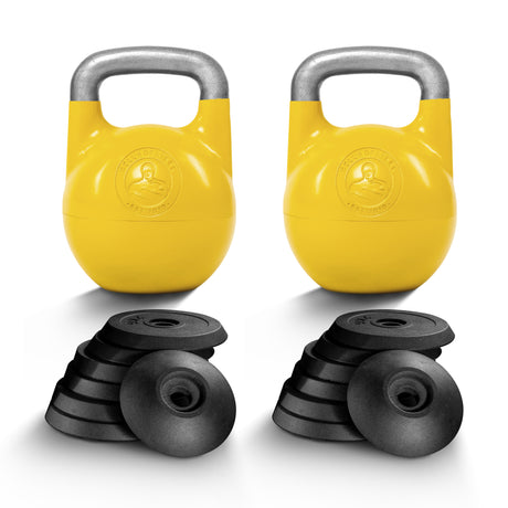 Two yellow Bells of Steel Adjustable Competition Kettlebells with metallic handles are behind two stacks of black weight plates, each kettlebell featuring a round logo, all set against a plain white background.