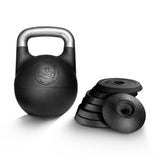 A Bells of Steel Adjustable Competition Kettlebell with a silver handle stands beside stacked black weight plates on a white background.
