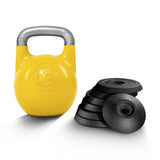A Bells of Steel Adjustable Competition Kettlebell with a silver handle is placed beside several black weight plates, all set against a white background.