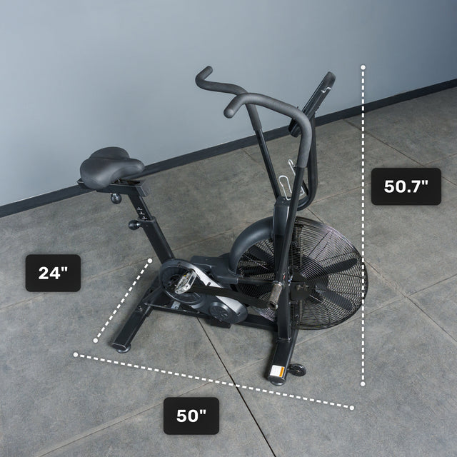 A Bells of Steel Residential Air Bike with Wind Guard, in black, stands on a gray tiled floor—ideal for home gyms. Dimensions: 24-inch seat height, 50-inch base length, and 50.7-inch handlebar height are shown.
