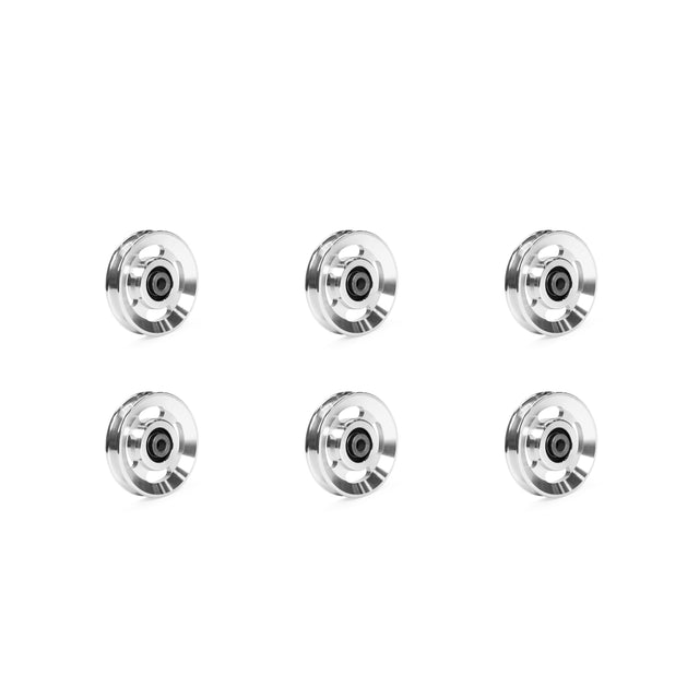 Six aluminum pulley wheels from Bells of Steel are displayed in two vertical columns on a plain white background, featuring a striking black core encased in a shimmering silver rim.