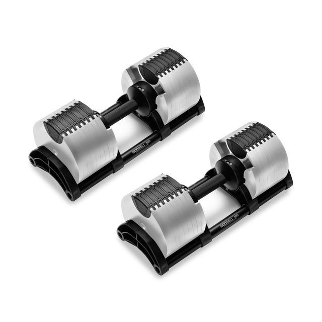 Two Nuobell NÜOBELL Adjustable Dumbbells with knurled handles and machined steel weight plates sit on black stands against a white backdrop, boasting a sleek, modern design perfect for home gyms.