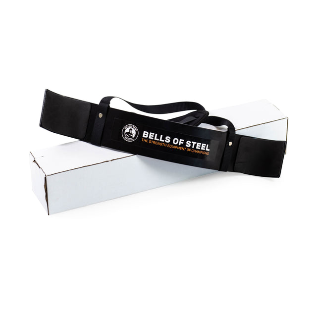 An aluminum Arm Blaster branded by Bells of Steel sits on a white box, crafted to ensure proper workout form.