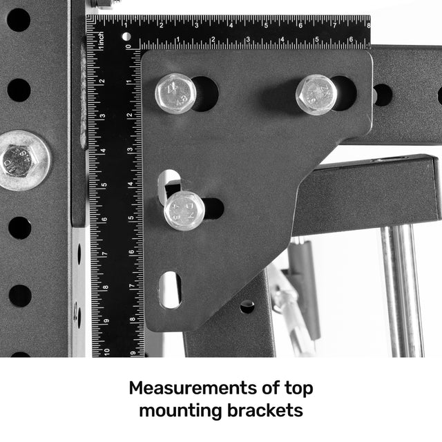 Close-up of metal brackets with measurement markings for the Bells of Steel Smith Machine Rack Attachment. Several bolts secure the brackets, and rulers are attached. Text below reads, "Measurements of top mounting brackets.