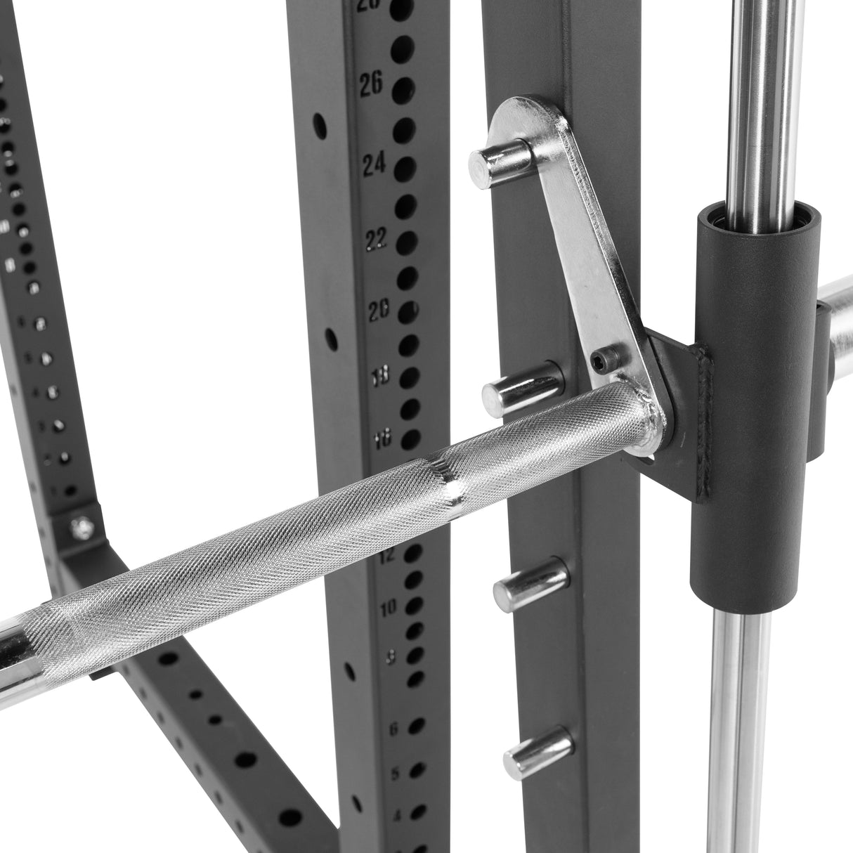 A close-up of a Bells of Steel Smith Machine Rack Attachment shows the knurled barbell on a solid power rack, featuring numbered holes for adjustable heights—suggesting premium quality fitness equipment.