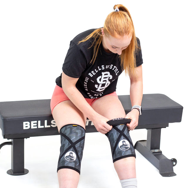 Female model putting on Classic Knee Sleeves