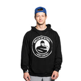 Wearing the Bells of Steel Bamboo Hoodie, featuring a buttery-soft bamboo blend and "EST. 2010" text, a person stands against a white background highlighting their fit figure. They smile slightly while looking at the camera under their blue cap.