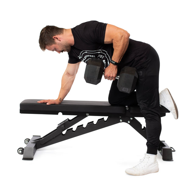 A person in a black outfit and white shoes performs a bent-over dumbbell row, kneeling on a Buzz-Saw Heavy-Duty Adjustable Bench by Bells of Steel, using one hand for support while lifting the dumbbell with the other.