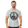A smiling man with short hair and a mustache wears a light gray Bells of Steel Bamboo T-Shirt featuring a muscular figure logo and "Est. 2010" text, standing against a white background.