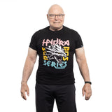 An older man with glasses and a smartwatch smiles against a white background, wearing the Bells of Steel Bamboo T-Shirt—a black sustainable workout shirt with a dragon graphic and colorful "Hydra Bass Series" text.