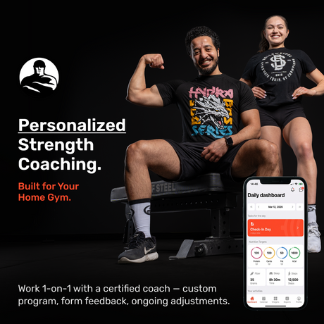 Two people in athletic wear pose confidently in a gym with a phone displaying the Bells of Steel Online Coaching app, highlighting personalized fitness programs from Bells of Steel.
