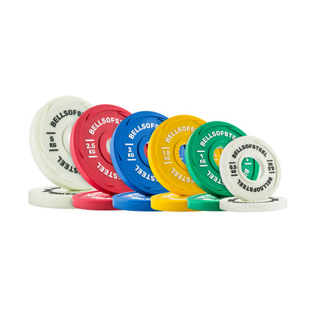 A set of Bells of Steel Urethane-Coated Change Plate Sets—colorful plates in white, red, blue, yellow, and green—stand upright in a row, each clearly labeled with its weight for lasting durability.