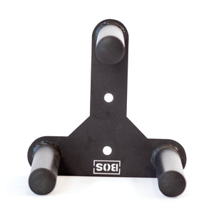 The Bells of Steel Change Plate Storage Pegs is a black metal wall mount bracket with three cylindrical pegs arranged in a triangle, ideal for organizing Olympic change plates. It features two mounting holes and an upside-down "SIS" logo at the bottom.