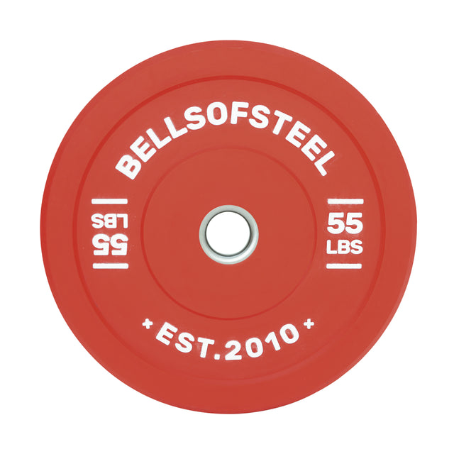 The Bells of Steel Colored Bumper Plate is red, marked "55 LBS" and "BELLSOFSTEEL" in white text, with a stainless steel center ring. The phrase "EST. 2010" elegantly enhances its classic appeal.