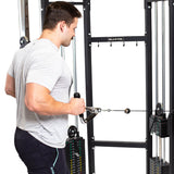 A man in a gray t-shirt uses the Bells of Steel Multi Purpose Close Grip Cable Attachment on a cable machine, pulling the handle toward his torso during a row exercise.