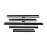 A set of black metal car parts on a white background, featuring long, narrow strips and sections with attachment holes, echoing the precision of the Bells of Steel Commercial Interchangeable Weight Rack.