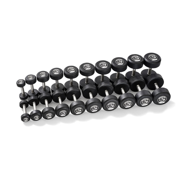 A grid of Bells of Steel Urethane Dumbbells, featuring commercial-grade black dumbbells with silver stainless steel heads, is displayed against a white background. The dumbbells are aligned in parallel rows, increasing in size from left to right.