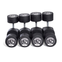 Five pairs of Bells of Steel Urethane Dumbbell Sets, labeled 85–100 lbs, are arranged in a row with circular logos on the ends—demonstrating commercial-grade quality for serious lifters.