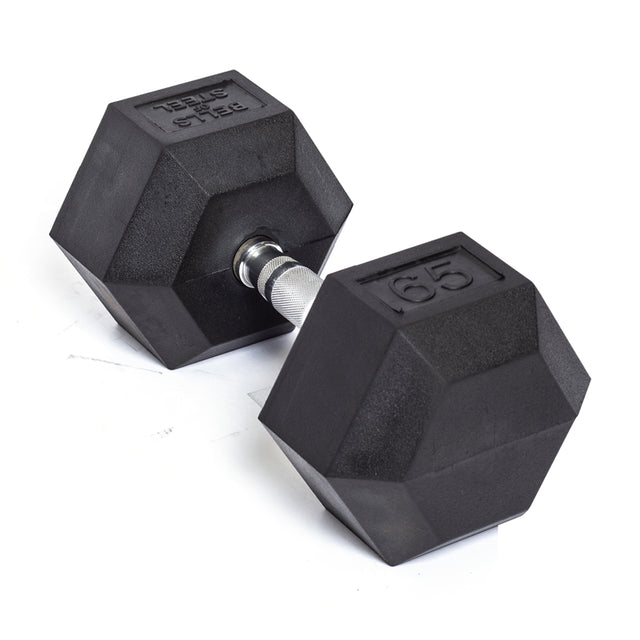 A black Ergo Rubber Hex Dumbbell from Bells of Steel, featuring a commercial-grade design with a silver handle and labeled as 65, rests on a white surface.