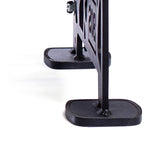 Close-up of the base of a black metal divider or screen with a geometric cutout design, similar to Bells of Steel's Commercial Interchangeable Weight Rack - Components Only. It rests on two rectangular feet on a white surface.