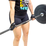 Wearing Bells of Steel Classic Figure 8 Lifting Straps, a person in black shorts and a graphic T-shirt grips a loaded barbell. The photo focuses on their lower body and arms, highlighting grip strength against a white background.