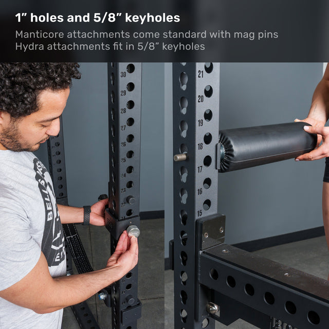 A man adjusts a bolt on the Bells of Steel Manticore Flat Foot Power Rack Builder (3" x 3", 1" holes), while a woman holds a pad attachment. Text highlights compatibility with both Manticore and Hydra attachments, making this rack an ideal addition to any home gym.