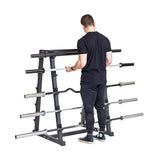 A man in black athletic wear selects a barbell from the middle row of the Bells of Steel Fixed Barbell Rack, with multiple barbells neatly stored on the rack against a white background.