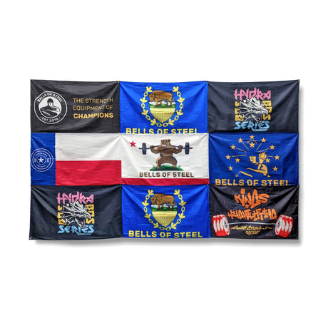 A set of nine vibrant Bells of Steel Flags featuring weightlifting designs and slogans, arranged in a rectangular grid—ideal gym decor for any space.