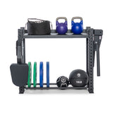 The Bells of Steel Hydra Storage Builder is a compact rack that holds two kettlebells, a punching bag, five weight plates, a medicine ball, and an exercise ball. Its sturdy black frame with side pegs offers neatly organized vertical storage for all your workout gear.