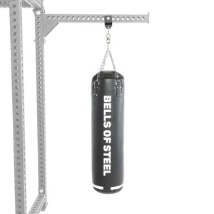 A Heavy Bag Set from Bells of Steel USA, featuring a black punching bag with “BELLS OF STEEL” printed in white, hangs from sturdy chains on a metal frame against a white background—making it the ideal upgrade to any power rack or heavy bag setup.