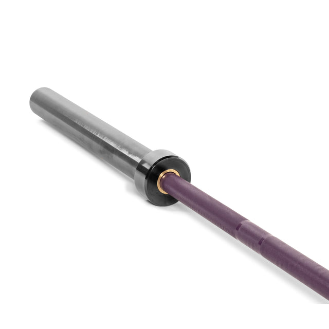 Close-up of the Bells of Steel Multi-Purpose Olympic Barbell – The Utility Bar features a purple grip and metallic sleeve. Ideal for powerlifting enthusiasts, its knurling and shiny finish highlight its durability, while the sleek end section showcases its weightlifting suitability.