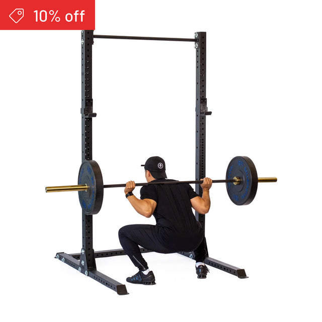 Wearing black workout gear and a cap, a person performs a barbell squat on the Bells of Steel Hydra Squat Stand Builder (3" x 3", ⅝" Holes). A red “10% off” tag appears in the top left on a white background.