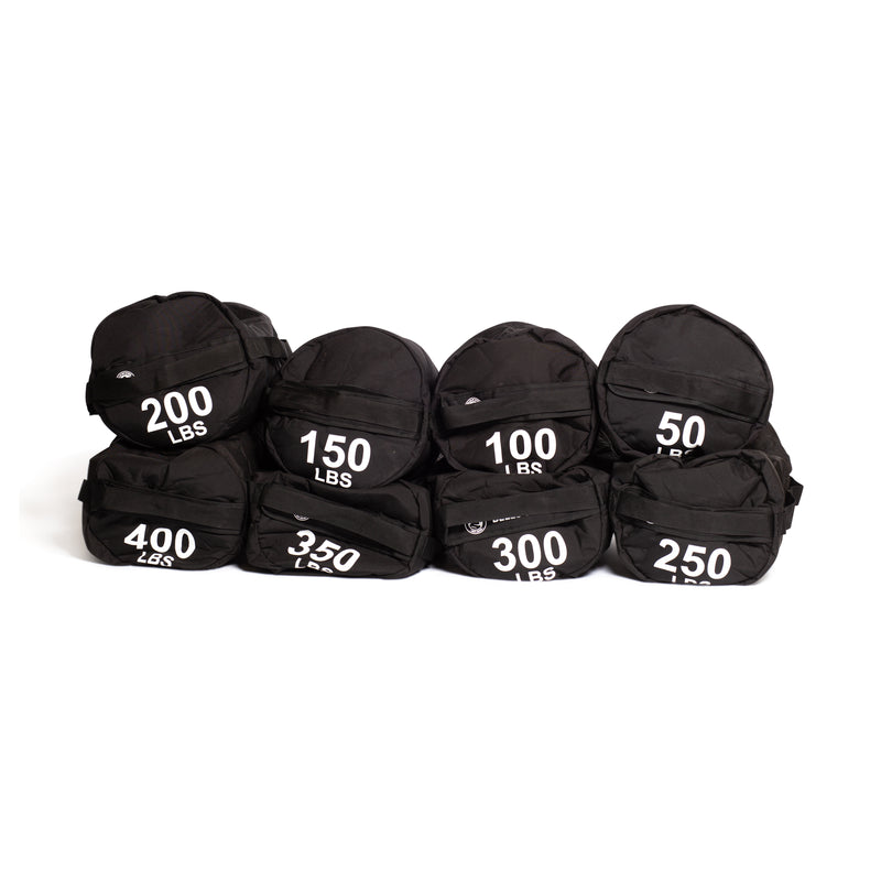 Seven black Bells of Steel Fitness Sandbag Sets, each labeled with weights from 50 to 400 lbs, are arranged in two rows against a white background, highlighting their durable construction—ideal for intense workouts.