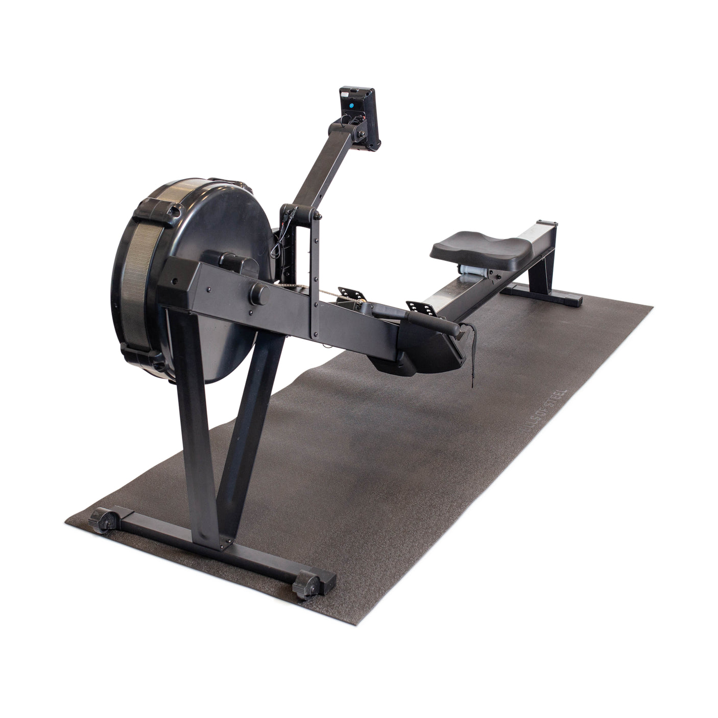 A black rowing machine is placed on a Bells of Steel Cardio Machine Floor Mat, shown against a white background. The rower includes a seat, footrests, handle, and digital display.