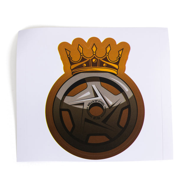 An illustration of a stylized black and brown barbell plate with "Wheels of Steel" and "#1 SB" topped with a golden crown forms a logo-like design for vinyl die-cut stickers by Bells of Steel. The plain white background highlights its durability and quality adhesive backing.