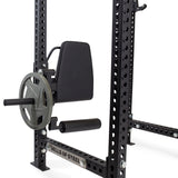 A close-up of the Bells of Steel Leg Curl / Leg Extension Rack Attachment mounted on a metal power rack, featuring an angled pad, foot support roller, and plate-loading pin—ideal for any serious home gym setup.