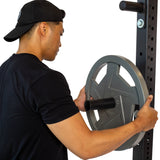 Male athlete putting Mighty Grip Weight plates on a rack using Bolt on Plate Pegs