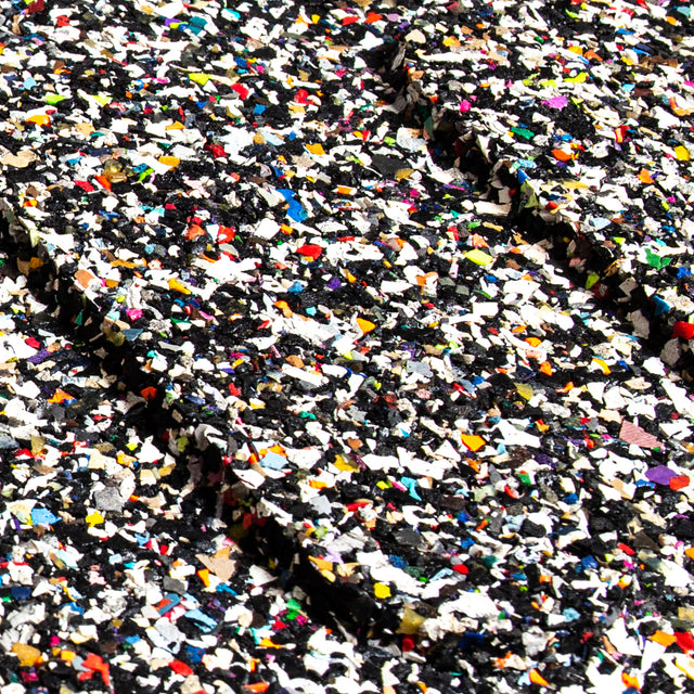 The Bells of Steel Rubber Flooring Gym Mat (39" x 39") showcases a textured, confetti-like surface of colorful fragments—blue, red, yellow, white—against a predominantly black background. Made from recycled rubber, this vibrant design is perfect for weightlifting mats and sound dampening.