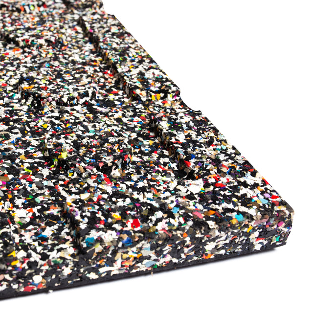 Close-up of a rectangular surface from Bells of Steel's Rubber Flooring Gym Mat 39" x 39", crafted with compressed multicolored recycled rubber speckles. The rough texture, showcasing black, white, red, blue, and yellow hues, makes it perfect for weightlifting mats or sound-dampening panels.