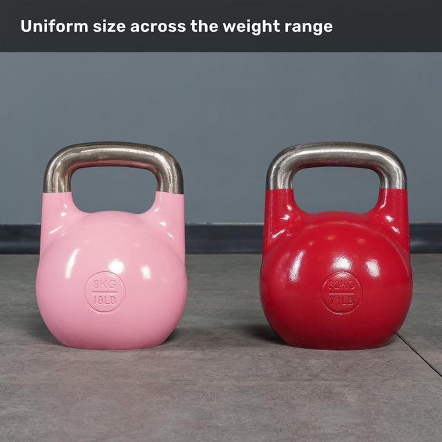 Two Bells of Steel Competition Kettlebells, one pink (8kg) and one red (32kg), sit on a gym floor. Both are identical in size, demonstrating the uniform size across the weight range.