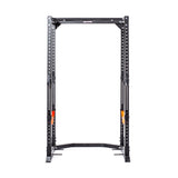 The Bells of Steel Light Commercial Power Rack (2.3" x 2.3", ⅝" holes) is a black rack for weightlifting, featuring multiple barbell height options and bright orange safety catches, ideal for safe home training. Shown on a white background.