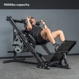 A man uses the Bells of Steel Leg Press Hack Squat Machine, loaded with weight plates, in a gym. Text at the top reads "1000lbs capacity.