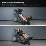 Two people use the Bells of Steel Leg Press Hack Squat Machine in a gym—one with resistance bands, the other with a standard press—showcasing this 2-in-1 machine’s versatility for any home gym.