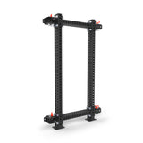 The Bells of Steel Manticore Folding Power Rack Builder, with true 3" x 3" perforated black metal beams and red corner accents, assembles with nuts and bolts. It supports up to 1,000 pounds and features a sturdy industrial design.