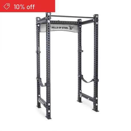 The Manticore Four Post Power Rack Builder (3" x 3", 1" Holes) by Bells of Steel stands sturdy in gray steel, ideal for any home gym. A red "10% off" banner appears in the top left on a white background.