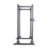 The Bells of Steel Manticore Flat Foot Power Rack Builder has a gray metal frame with 1" holes for modular components, adjustable height, and triangular supports. It's designed for weightlifting, ensuring stability and supporting up to 1,000 pounds.