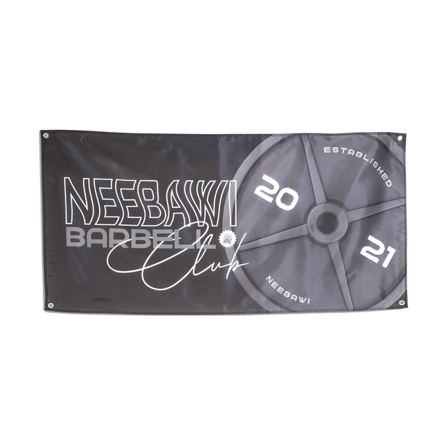 A black gym flag from Bells of Steel displays a large barbell plate graphic, featuring the text "NeebawI Barbell Club" and "Established 2021," making it perfect for decorating a home gym.