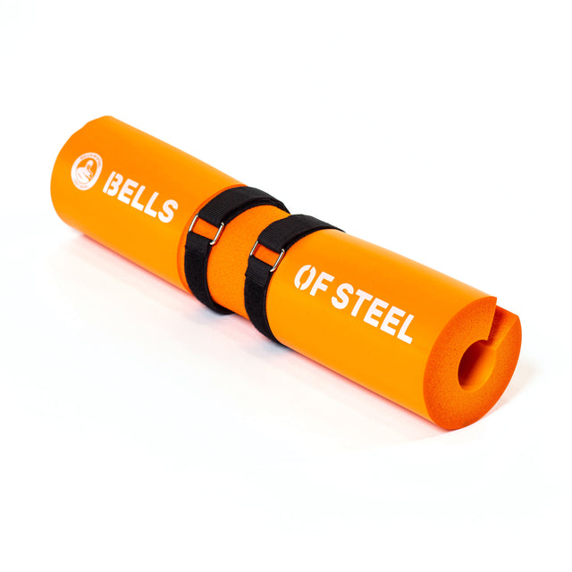 The orange ergonomic foam Barbell Pad by Bells of Steel features black Velcro straps, "BELLS OF STEEL" in white, and offers weightlifting comfort and protection.