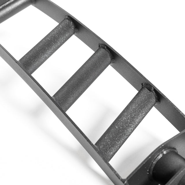 A close-up of the Bells of Steel Arch Nemesis Swiss Bar reveals its black, metallic four-rung design with angled grips for stability. Its matte finish and textured surface mirror specialty barbells in an industrial, sturdy style.